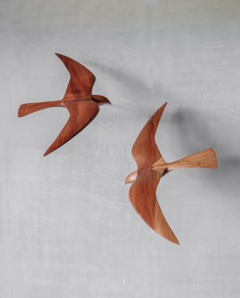 Pair of wooden falcon wall-mounted sculptures in minimalist design, shown side view.